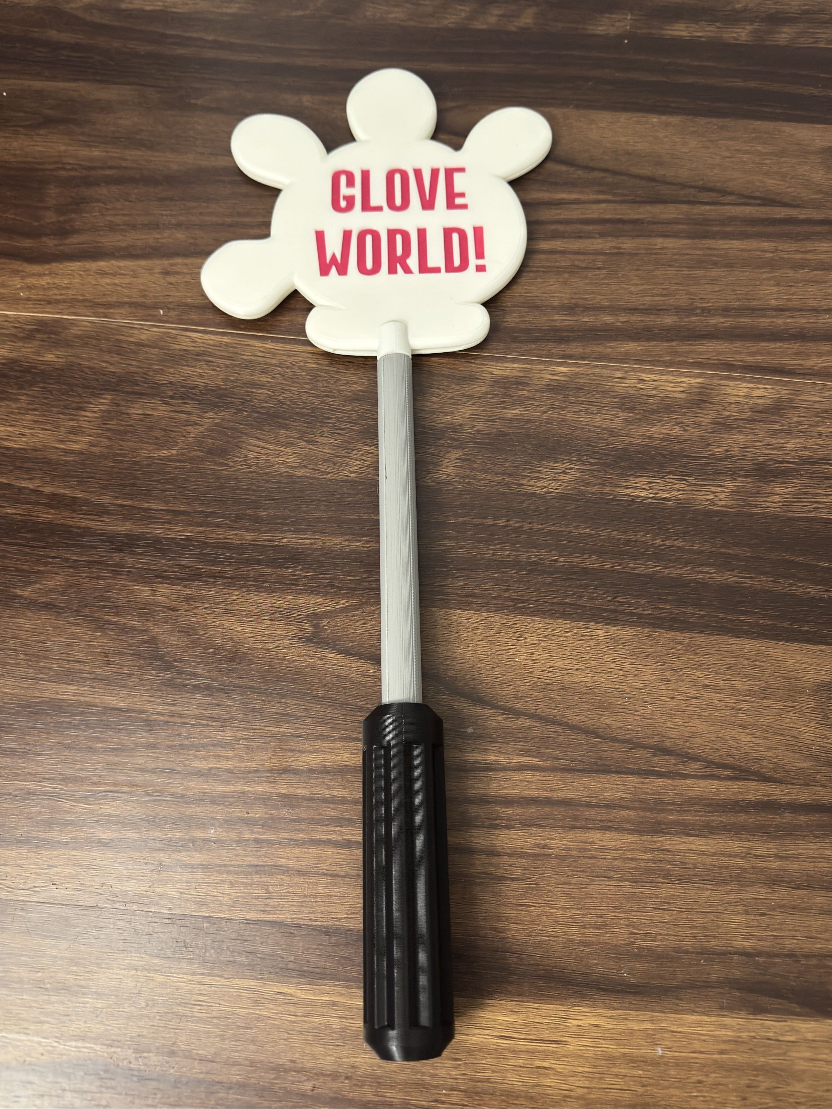 Glove shaped sign with 'Glove World!' text on a wooden surface