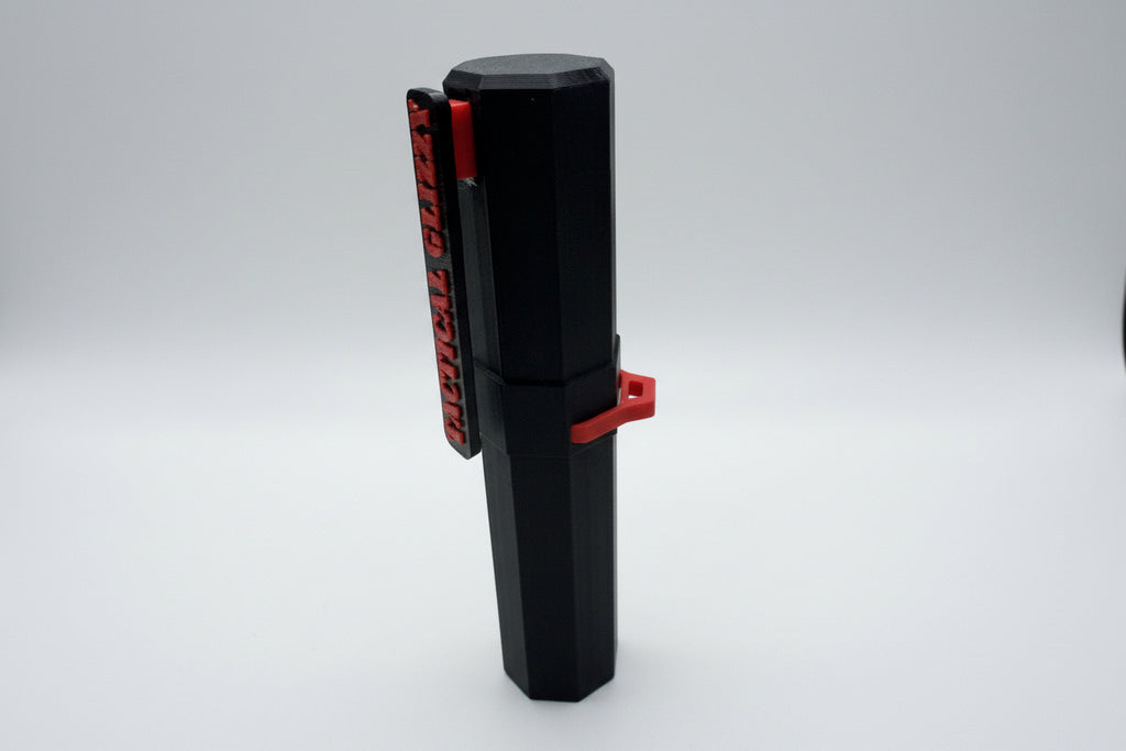 Black and red tool against a tiled wall