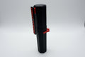 Black and red tool against a tiled wall