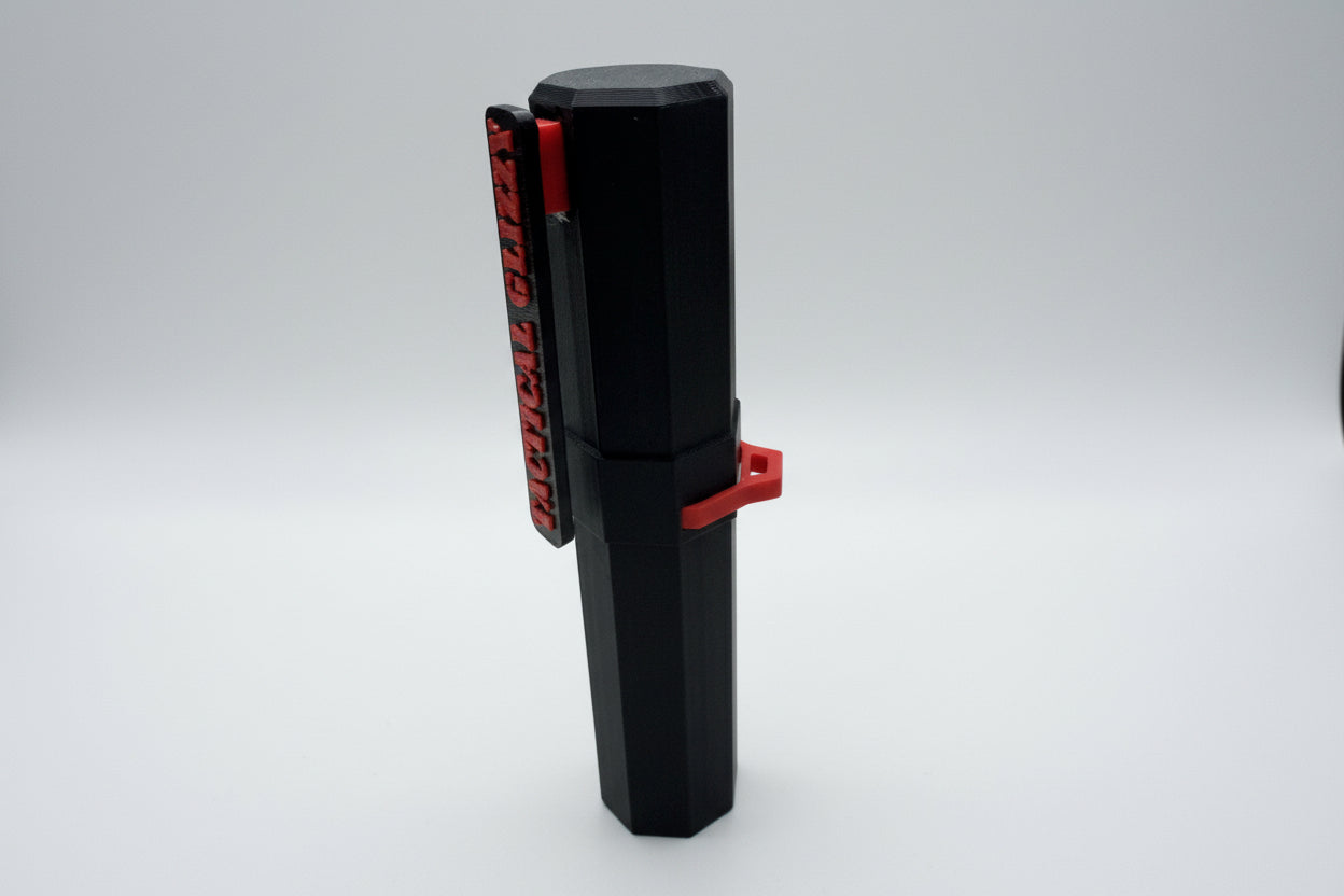 Black and red tool against a tiled wall